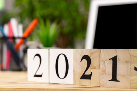 Wooden cubes with year 2021 on working table