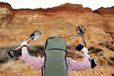 Male with metal detector found something on the beachの写真素材