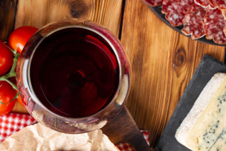 Wineglass with red wine and meat cuts boardの写真素材