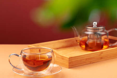 Glass teapot and cup with black teaの写真素材