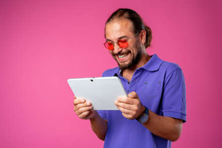 Funny hipster man using his digital tablet