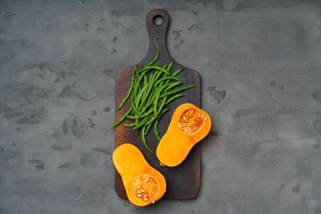 Raw orange pumpkin and wooden cutting board