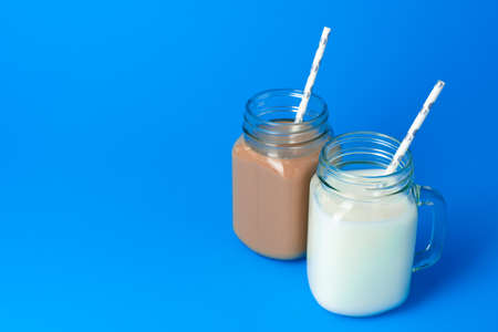 Glass jar with fresh milk against blue backgroundの写真素材