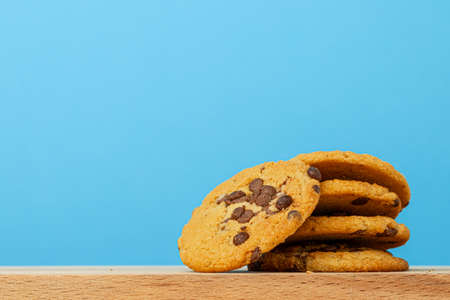 Stack of chocolate chip cookies against blue background