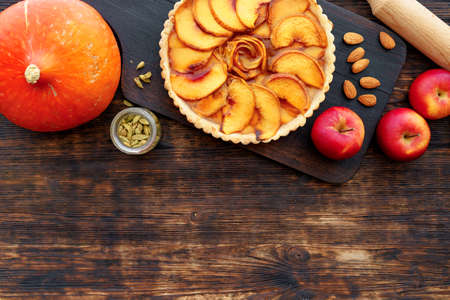 Apple tart pie and red apples on wooden tableの写真素材