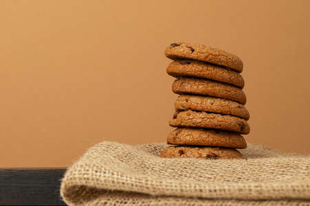 Stacked chocolate chip cookies against beige background
