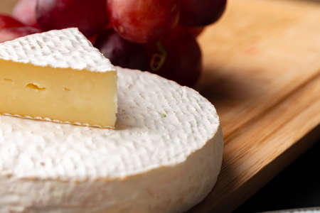 Close up photo of cut cheese and grapesの写真素材