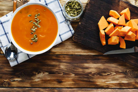 Creamy pumpkin soup on a wooden tableの写真素材