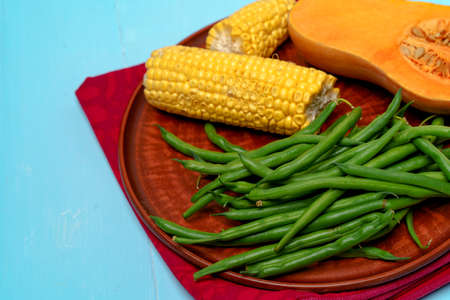 Green beans in clay plate with vegetables
