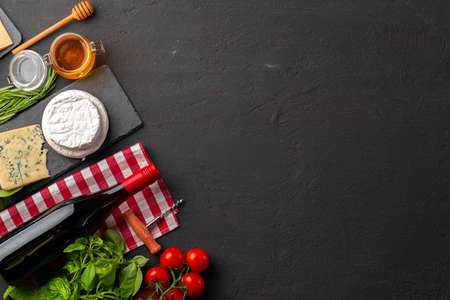 Composition with wine bottle and cheese assortment on grey background