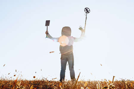 Man with metal detector equipment searching for metal goods in the field