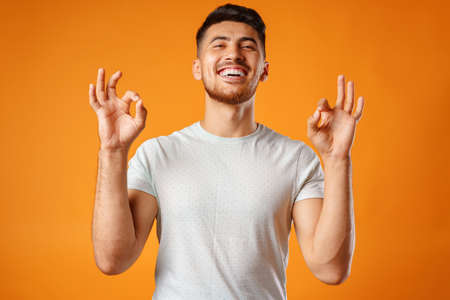 Hispanic young handsome man singing with joy in microphoneの写真素材