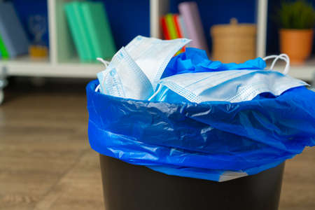 Used infectious masks and medical glove in the trash binの写真素材