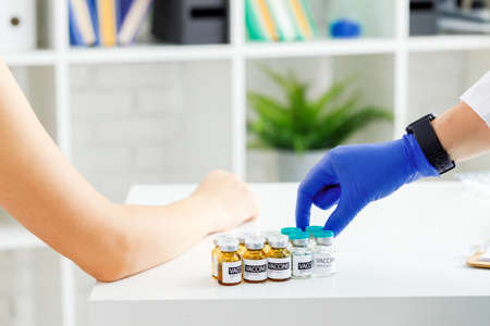 Hand of a doctor taking vial with sars-cov-2 vaccine