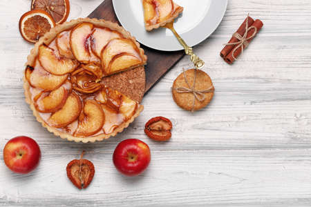 Top view of an apple pie on white wooden surface
