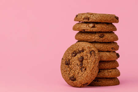 Stacked chocolate chip cookies against pink backgroundの写真素材