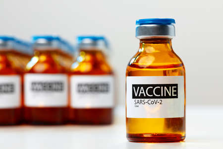 Sars-cov-2 vaccine vial bottles on white tableの写真素材