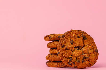 Stacked chocolate chip cookies against pink backgroundの写真素材