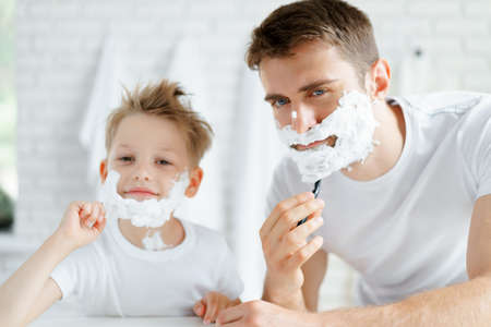 Father and his little son shaving togetherの写真素材
