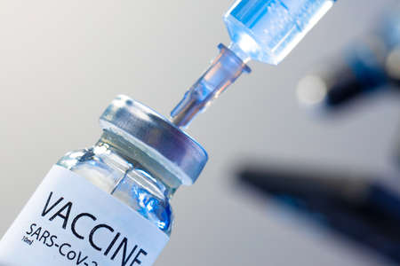 Covid-19 vaccine bottle with a syringe taking the vaccine from itの写真素材