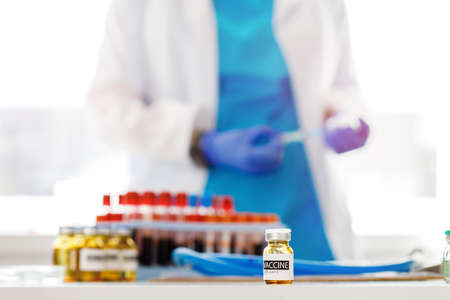 Vials of vaccine and blood samples on doctors table