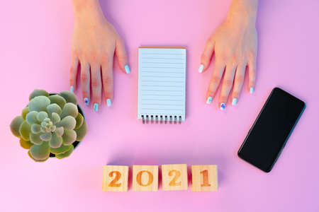 Female hands and open notepad on pink backgroundの写真素材