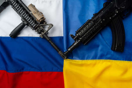Flags of Russia and Ukraine folded together with rifle gunsの写真素材