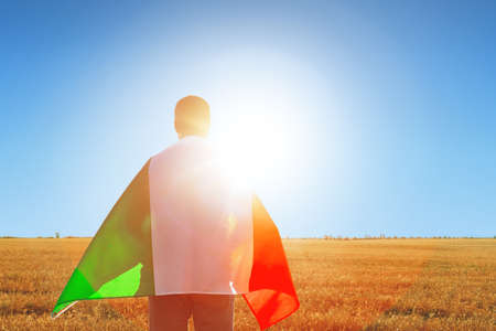 Man with a flag of Italy standing in fieldの写真素材
