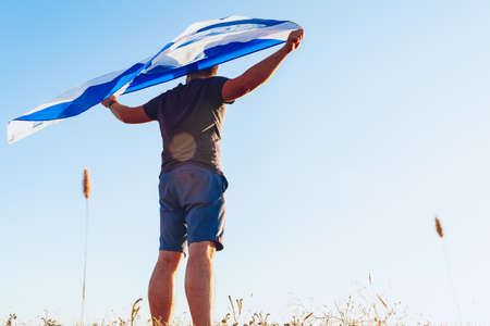 Man with a flag of Scotland standing in fieldの写真素材