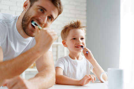Dad and little son brushing teeth togetherの写真素材
