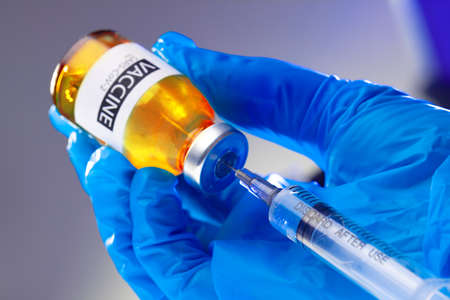 Covid-19 vaccine bottle with a syringe taking the vaccine from it