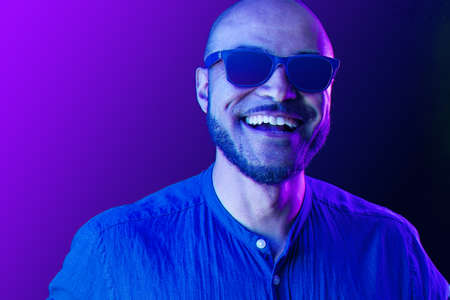Portrait of afro american man model in glasses in neon lightの写真素材