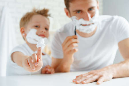 Father and his little son shaving togetherの写真素材