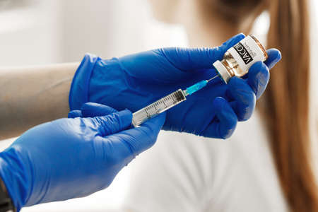 Doctor hands holding covid-19 vaccine preparing for vaccination of a patient
