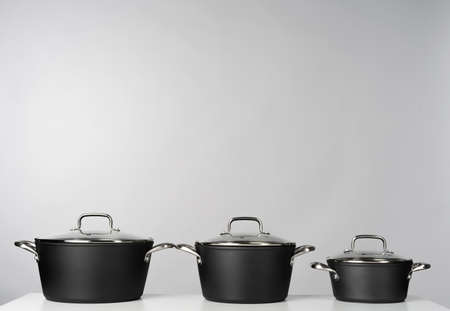 New domestic cookware on grey background close up