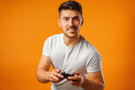 Handsome mixed-race man holding video games joystick