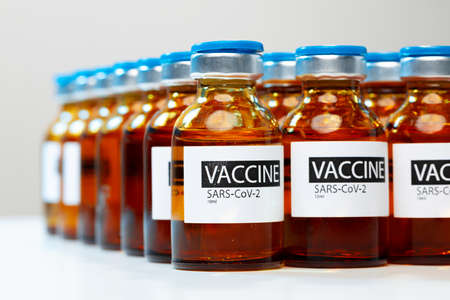 Sars-cov-2 vaccine vial bottles on white tableの写真素材
