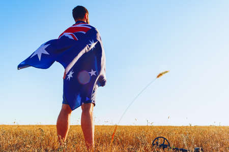 Man with a flag of Australia standing in fieldの写真素材