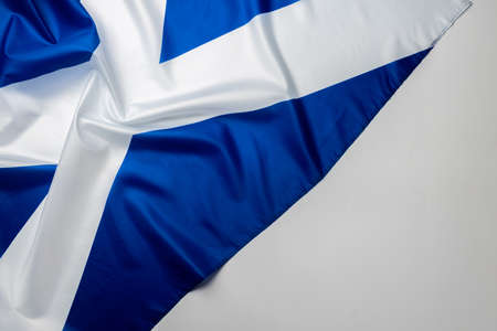 Rippled flag of Scotland lying on white surfaceの写真素材