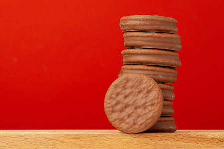 Glazed chocolate cookies stack on red backgroundの写真素材
