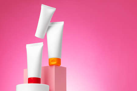 Blank white cosmetic container against pink background