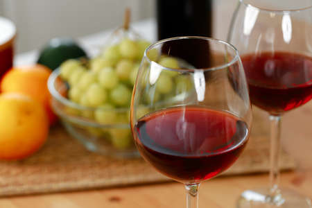 Two wine glasses with red wine on wooden kitchen counterの写真素材