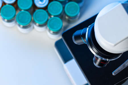 Medical vial with medication near microscope photo