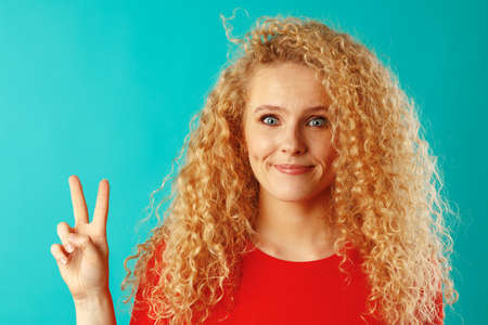 Young happy smiling woman showing victory sign