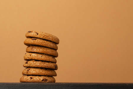 Stacked chocolate chip cookies against beige background
