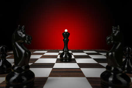 Chess board with figures on dark red backgroundの写真素材
