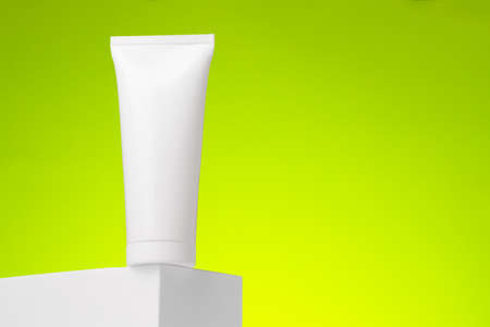 White blank cosmetic package against green background