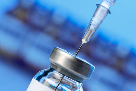 Vaccine bottle with a syringe taking the vaccine from it