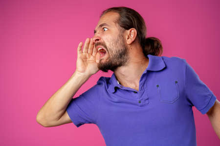 Very angry middle-aged man shouting against pink background