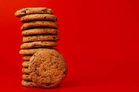 Chocolate chip cookies in stack on red background